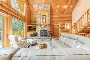 a living room with a couch and a fireplace at Mountain Cabin with Hot Tub 4 Mi to Shaver Lake! in Shaver Lake