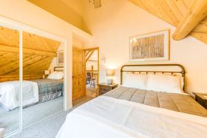 a bedroom with two beds and a glass doorway at Mountain Cabin with Hot Tub 4 Mi to Shaver Lake! in Shaver Lake