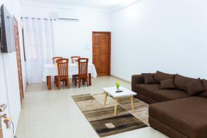 sala de estar con sofá y mesa en JRéside Appart XL02 50m2 centre-ville, en Cotonou