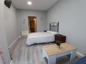 RomilloにあるEstudios El Puntual de Romilloの白いベッドルーム(ベッド1台、テーブル付)