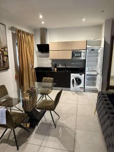 a kitchen with a glass table and chairs at Pine Court in Accra