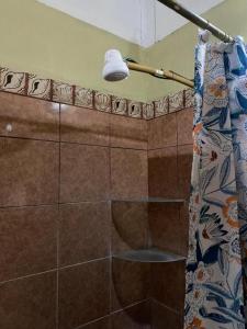 y baño con ducha y cortina de ducha. en Holiday Home Mauras Tropical en Puntarenas