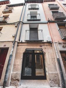 un edificio con una puerta y ventanas negras en Casa San Juan - Habitaciones privadas Logroño, en Logroño