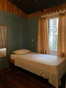 a bedroom with a large bed with a window at Holiday Home Mauras Tropical in Puntarenas