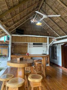 Habitación con mesas y sillas de madera y techo. en Holiday Home Mauras Tropical en Puntarenas