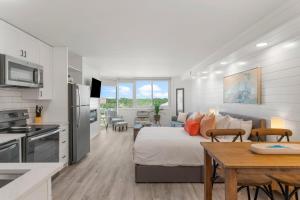 パナマ・シティ・ビーチにあるTop of the Gulf 622 Beach Front Resort Condo RENOVATED LIKE NEWのキッチン、リビングルーム(ベッド1台、テーブル付)