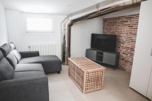 a living room with a couch and a tv at Casa San Juan - Habitaciones privadas Logroño in Logroño