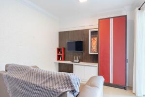 d'un salon avec une porte rouge et une télévision. dans l'établissement Apartamento em Bombas - Ótimo para Famílias, à Bombinhas