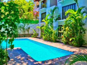 a swimming pool in front of a house at Casa Kaz: Penthouse 1 Bedroom in Zihuatanejo