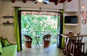 a living room with a balcony with a sliding glass door at Casa Kaz: Penthouse 1 Bedroom in Zihuatanejo
