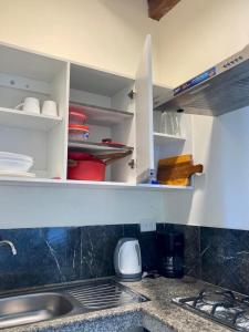 - un comptoir de cuisine avec des placards blancs et un évier dans l'établissement Rustica House frente al lago - Ayampe, à Ayampe