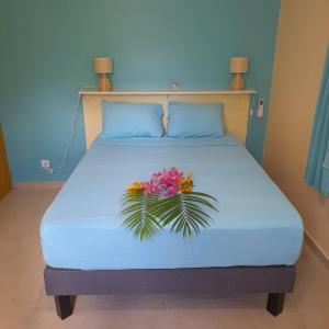 un letto con un mazzo di fiori sopra di canelle a Le Diamant