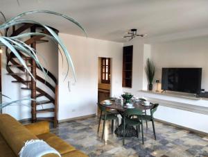 a living room with a table and chairs and a tv at Casa Basilico' Taormina in Taormina