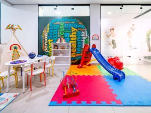 een speelkamer voor kinderen met een glijbaan en een speeltuin bij Hotel M Privilege Moema São Paulo in Sao Paulo