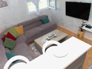 a living room with a couch and a tv at Apartment Kosta in Podgorica