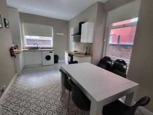 um quarto com uma mesa e cadeiras e uma cozinha em 4 Bedroom house, 8 min to city! em Manchester