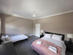 um quarto com uma cama grande e uma cama sidx sidx sidx em 4 Bedroom house, 8 min to city! em Manchester