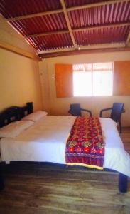 a bedroom with a large bed with a blanket on it at Mirador Playa Cristal Tayrona in Santa Marta