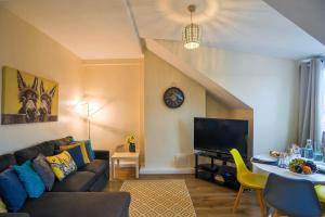 a living room with a couch and a tv at 1 bed Flat ''Charlie'' in Dewsbury Rd Leeds in Hunslet