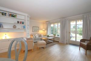 uma sala de estar com um sofá e uma mesa em Appartement-Freesensuen em Munkmarsch