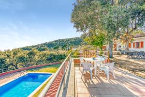 un patio con tavolo, sedie e piscina di Casa Roure-4BR-Piscina-BBQ-Vistas Mar-Ping-Pong a Sant Cebrià de Vallalta