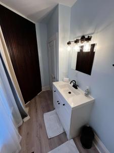 La salle de bains blanche est pourvue d'un lavabo et d'un miroir. dans l'établissement Charming & Newly Renovated 2BR in St Albans, à Saint Albans