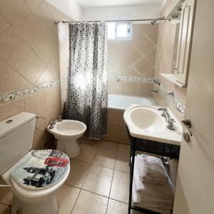 a bathroom with a toilet and a sink and a tub at Miliño Apart Hotel in Buenos Aires