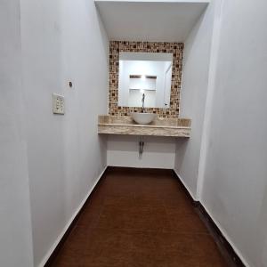 a bathroom with a sink and a mirror at Suítes Pitangueiras in Guarujá