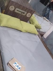 una cama con almohadas amarillas y un reloj en ella en House1963., en Santo André