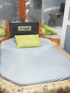 1 cama con almohada amarilla en una habitación en House1963., en Santo André