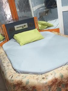 Una cama con una almohada amarilla encima. en House1963., en Santo André