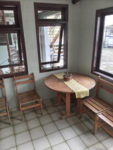 una mesa y sillas en una habitación con ventanas en House1963., en Santo André