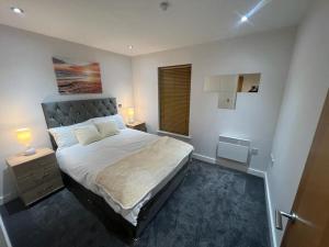 a bedroom with a large bed and a window at AO Arena flat Manchester, with parking in Manchester