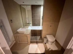 a bathroom with a tub and a toilet and a sink at AO Arena flat Manchester, with parking in Manchester