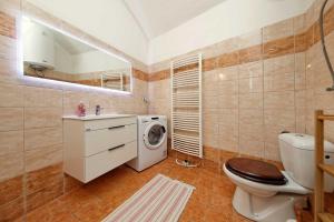 a bathroom with a washing machine and a toilet at Riverside Apartment in Prague