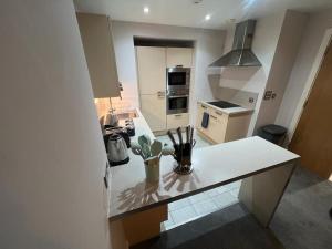 a kitchen with a white counter top in a kitchen at AO Arena flat Manchester, with parking in Manchester