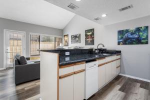 eine Küche mit weißen Schränken und einer schwarzen Arbeitsplatte in der Unterkunft KING BED Well-Located Cozy Townhouse Retreat in Gulfport + 15 Fotos