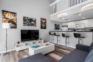 ein Wohnzimmer mit Fernseher und eine Küche in der Unterkunft KING BED Well-Located Cozy Townhouse Retreat in Gulfport