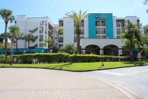 een straat voor een gebouw met palmbomen bij Best Western Plus Deerfield Beach Hotel & Suites in Deerfield Beach