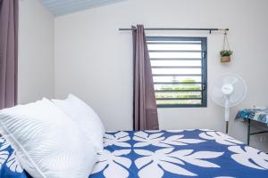 a bedroom with a blue and white bed with a window at Cosy Studio Anahoa 1 in Papeete in Papeete