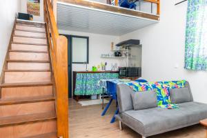 a living room with a staircase and a couch and a table at Cosy Studio Anahoa 1 in Papeete in Papeete