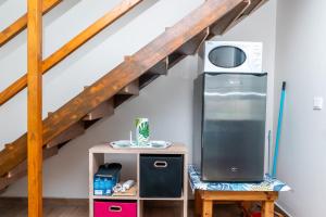 a kitchen with a refrigerator and a table with a chair at Cosy Studio Anahoa 1 in Papeete in Papeete