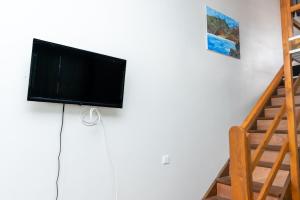 a flat screen tv on a wall next to a staircase at Cosy Studio Anahoa 1 in Papeete in Papeete