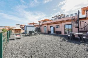 a patio with a table and chairs in front of a building at HolaOla HighClass Townhouse in Lajares