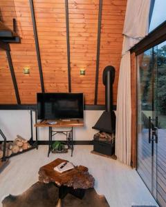 uma sala de estar com uma televisão e um fogão em Chalé no Litoral 01 em Torres