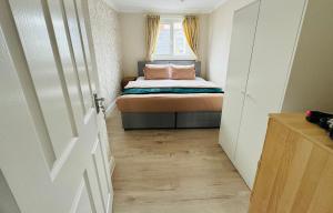 a small bedroom with a bed and a window at Entire 4br with cot, free street parking and garage in Sunderland