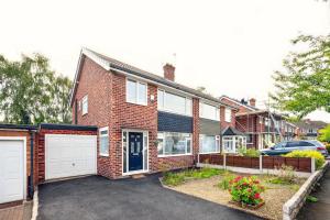 uma casa de tijolos com uma entrada e uma garagem em house in Heald Green village em Manchester