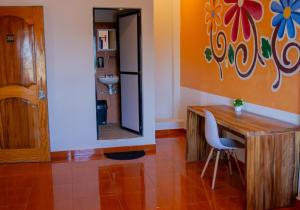 Cette chambre comprend un bureau, un miroir et une chaise. dans l'établissement Posada Girasol, à Puerto Escondido