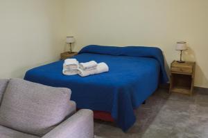 1 dormitorio con 1 cama con 2 toallas y 1 silla en Altos la Villa en San Rafael