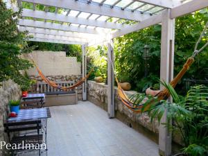 un patio con una hamaca bajo una pérgola en The Spirit Of Tzfat Villa en Safed